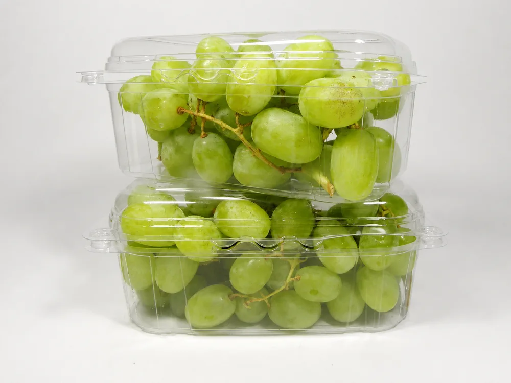 Green grapes packed in clear plastic fruit punnets for retail display