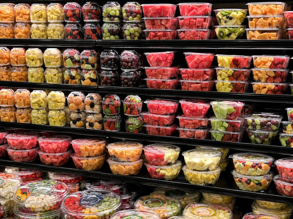 Packaged fresh fruit displayed in a supermarket produce section