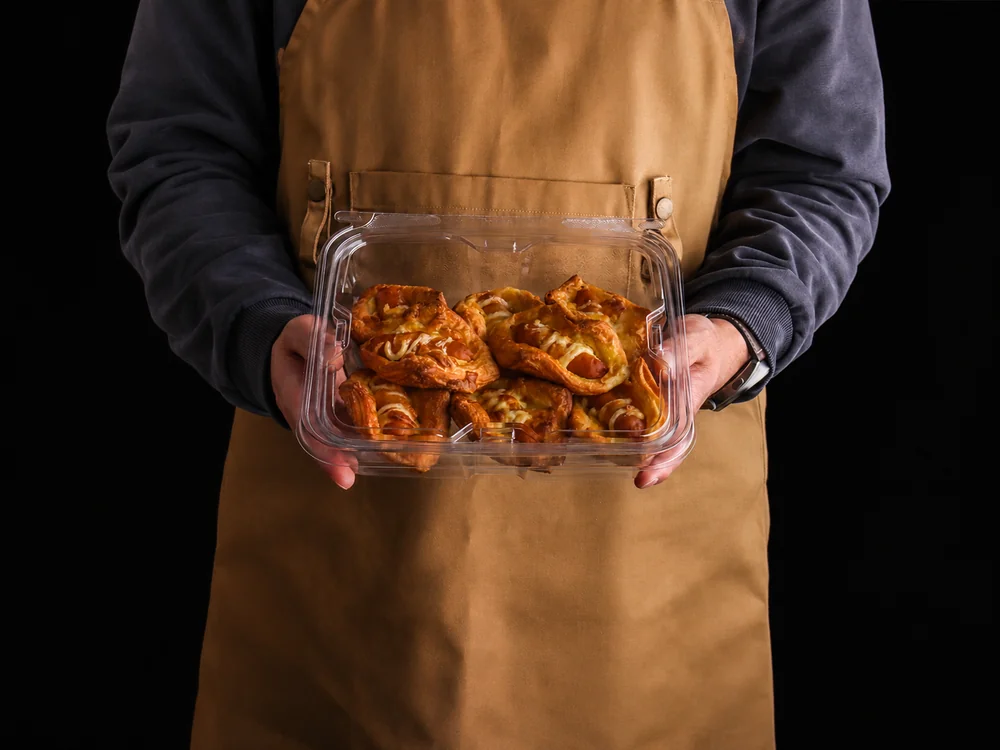 Person holding a tamper-evident bakery container