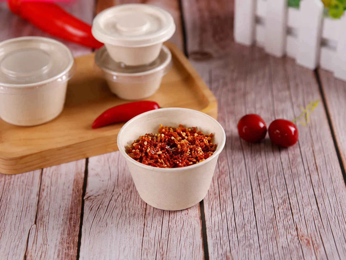 Disposable paper sauce cup filled with chili seasoning on a wooden table