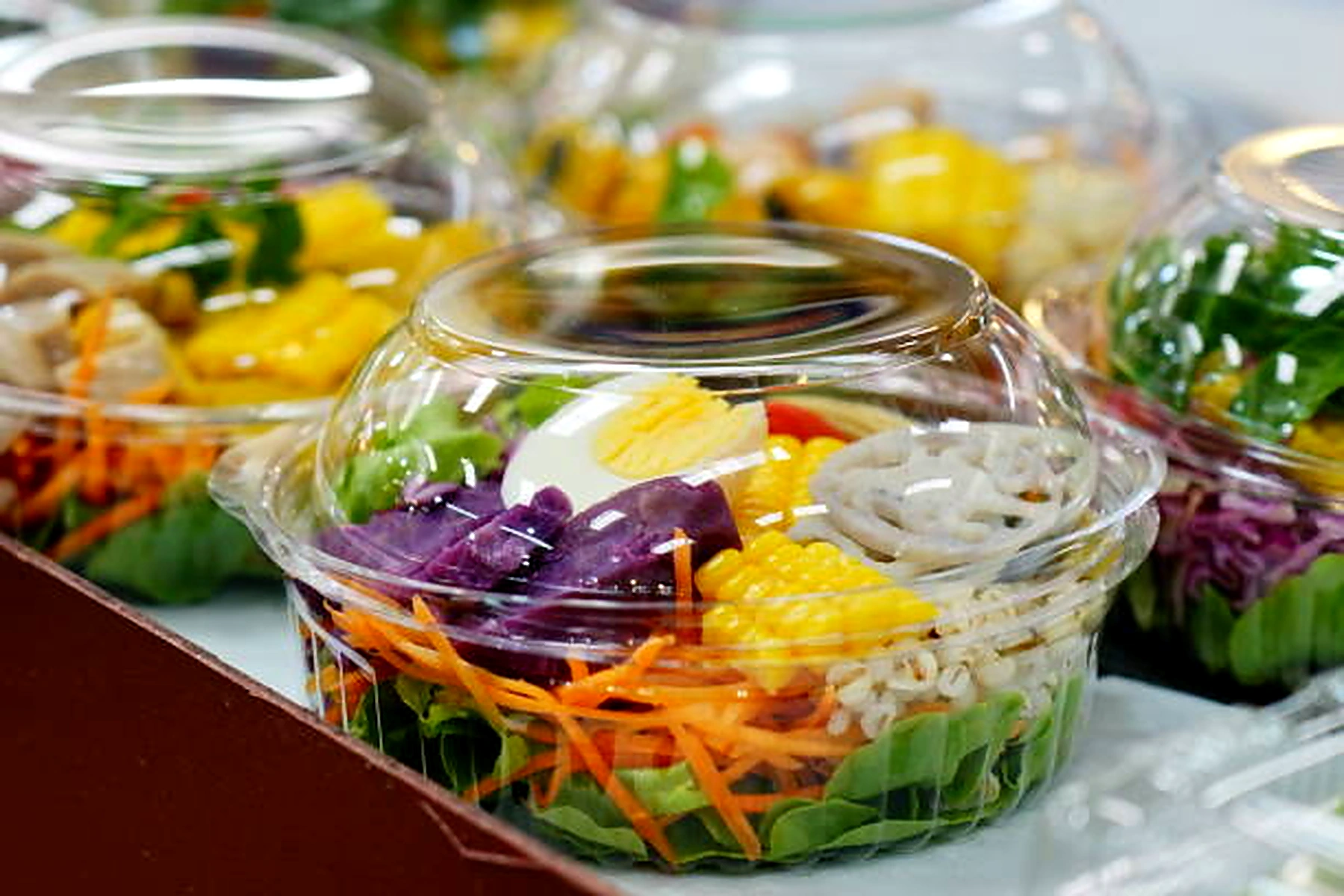 Round plastic salad bowl with lid on display