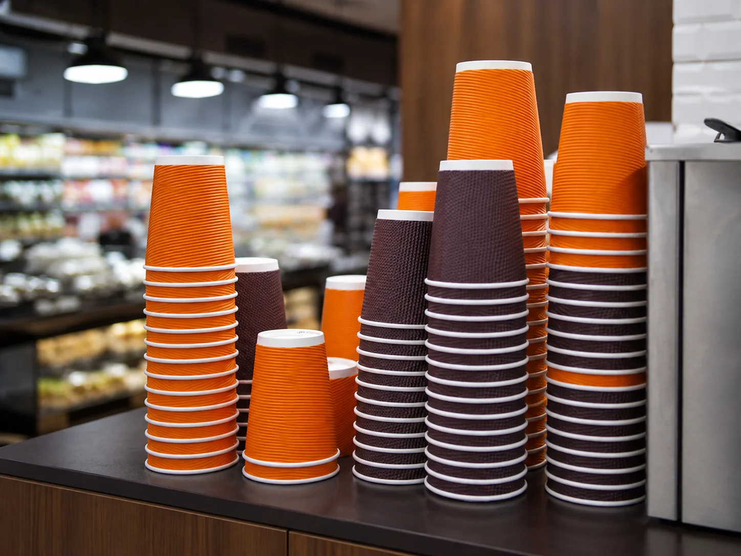 Stacks of colorful disposable paper cups for hot and cold beverages
