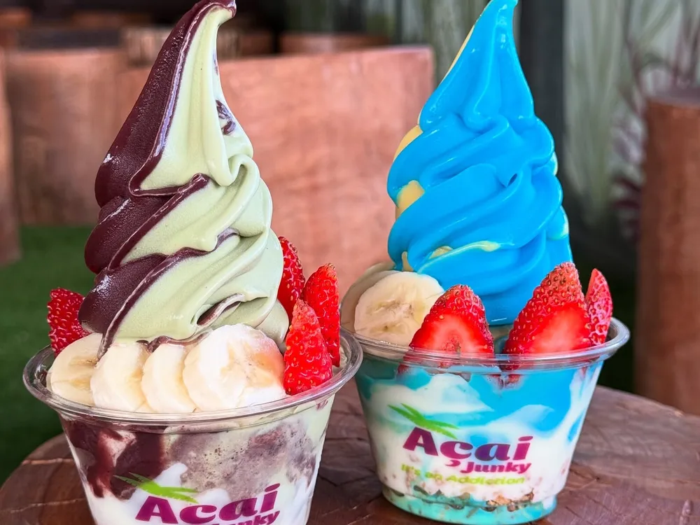 Small and large custom-printed Acai Junky wide-mouth deli cups with tall soft serve and fresh berries in Sydney Australia