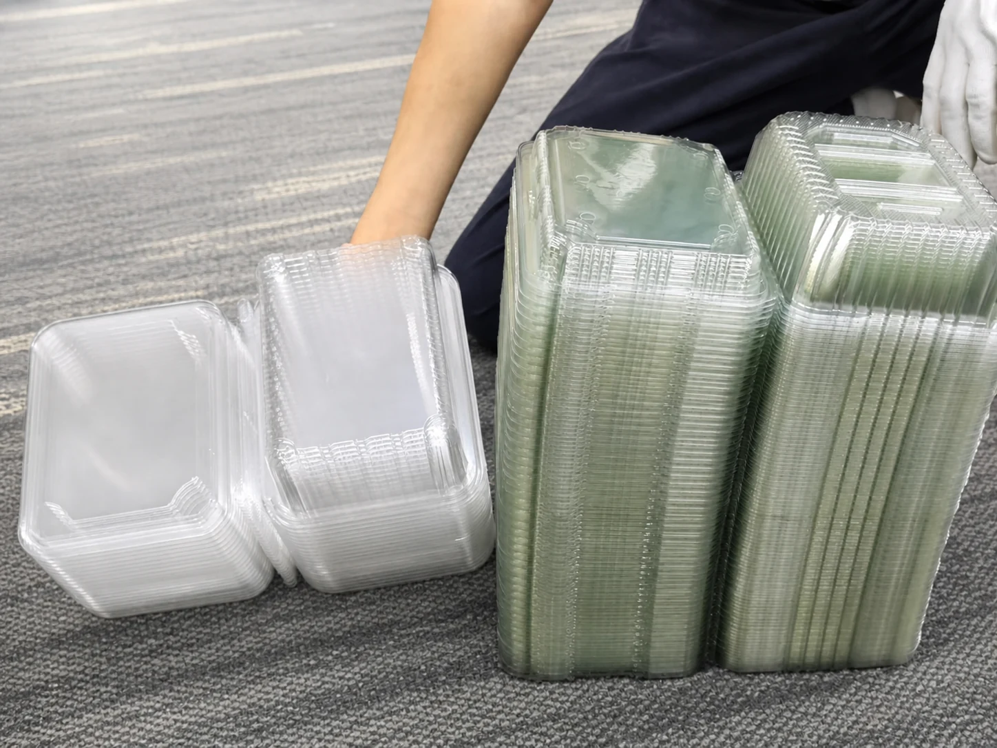 Food containers produced by different factories showing noticeable color differences.
