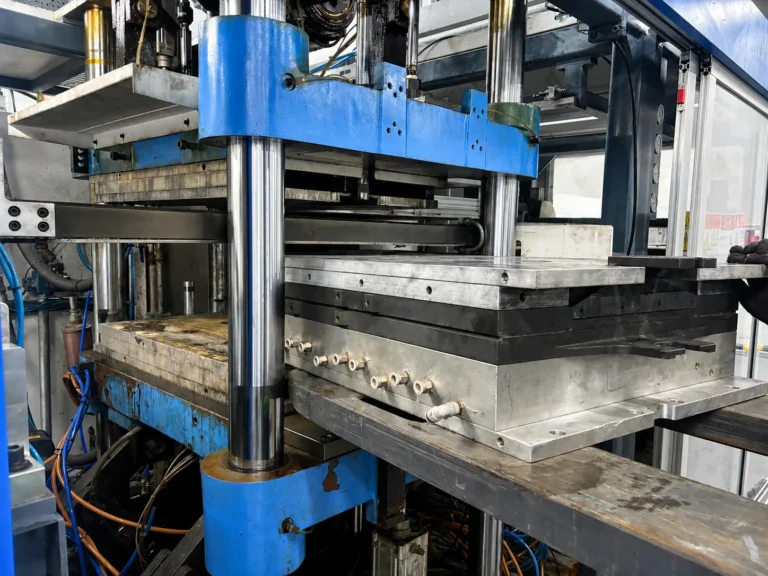 Food packaging mold loaded into a thermoforming machine for production.