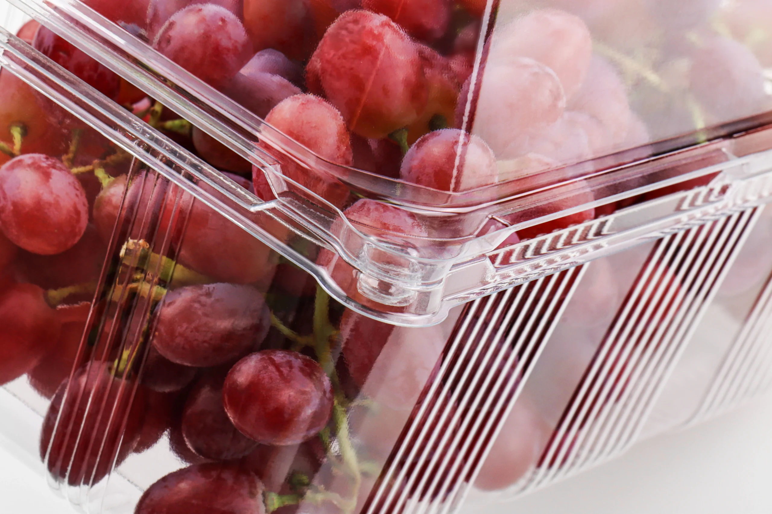 Rigid sidewall design reinforcing a clear grape container.